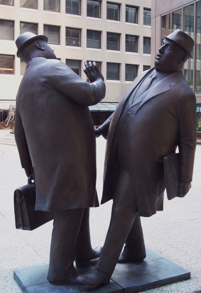 Statue of 2 business men bumping into one another